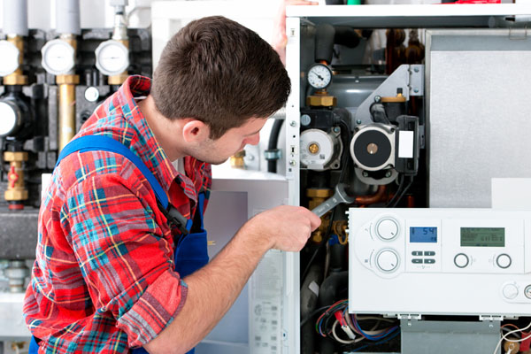 Heating technician repairing boiler controls in San Francisco