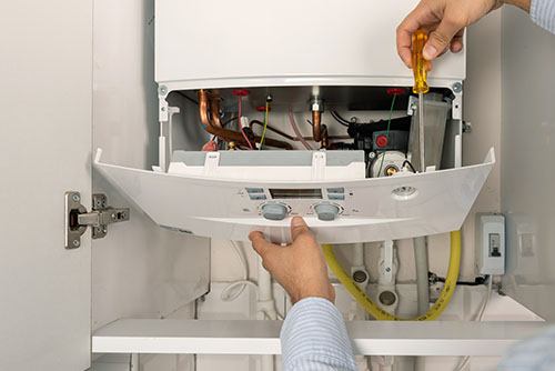 Heating technician repairing a residential boiler in San Francisco