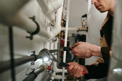 Technician inspecting commercial plumbing pipes in San Francisco