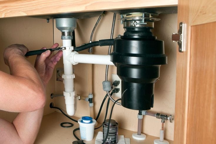 Plumber repairing a garbage disposal in San Francisco