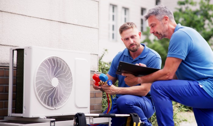HVAC technicians installing an outdoor air conditioning unit in San Francisco