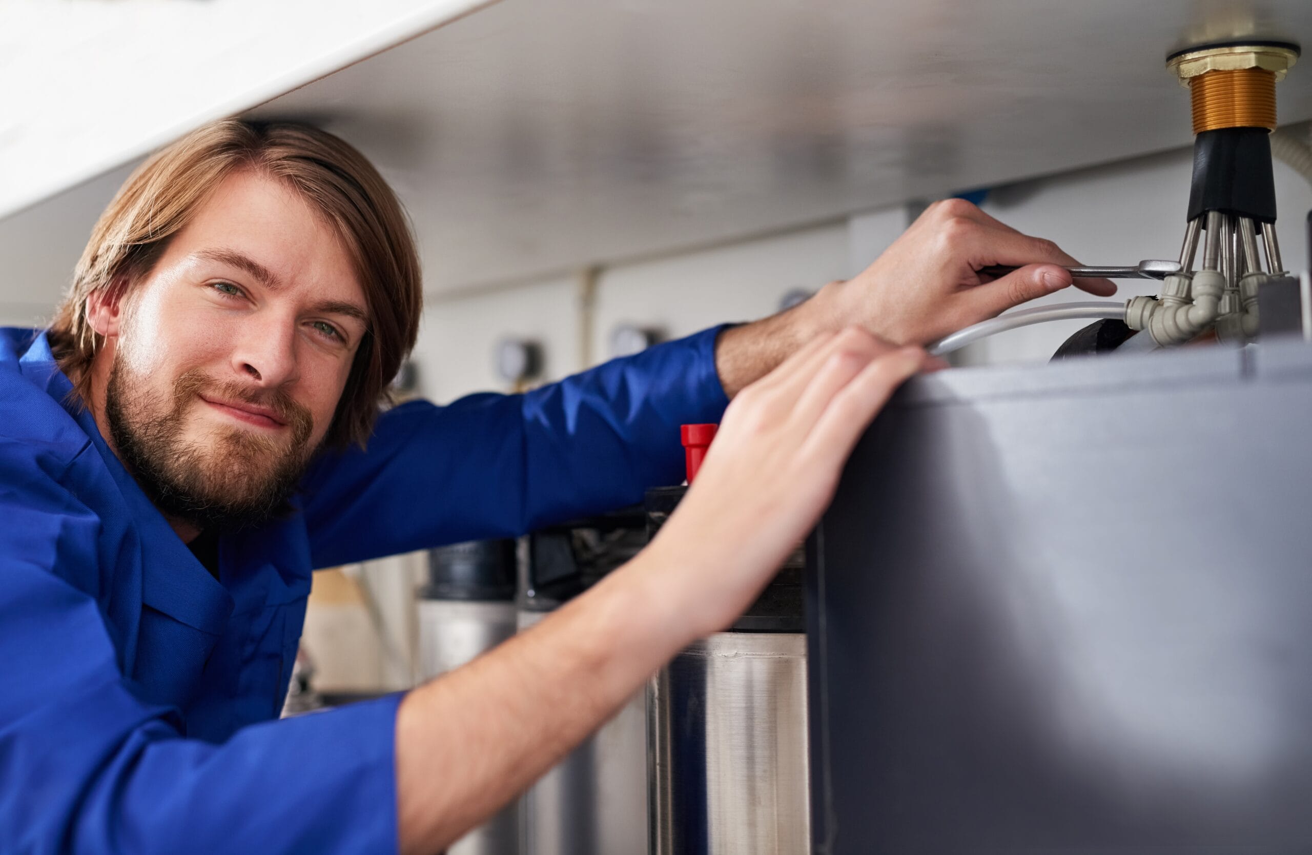 Technician servicing a residential water heater tank in San Francisco